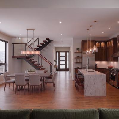 Modern open-concept living space with a kitchen, dining area, and staircase.